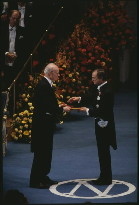 Harry Markowitz receiving the 1990 Prize in Economic Sciences at the Stockholm ceremony, on a flower-banked stage.